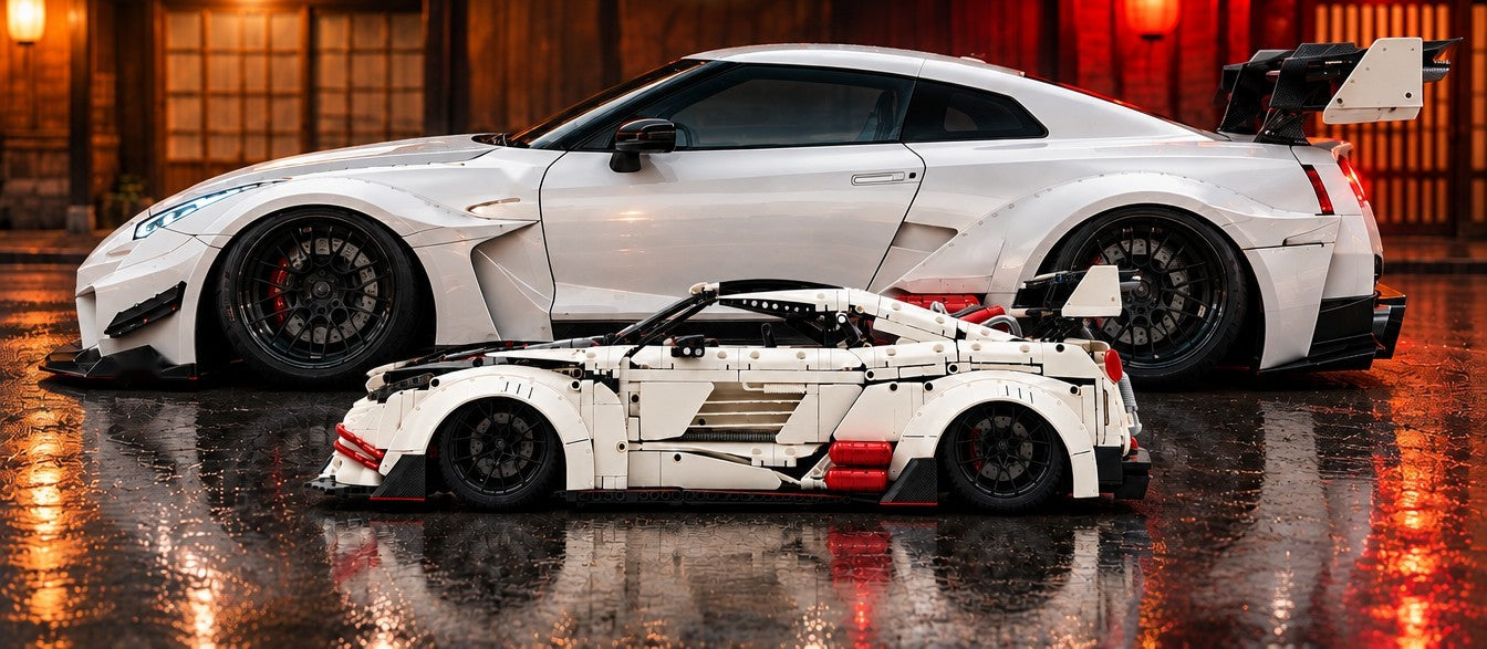 Le modèle widebody blanc devant une voiture widebody grandeur nature, sur une route mouillée de nuit